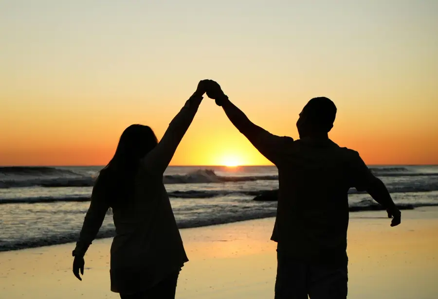 A loving couple embracing with a beautiful sunset in the background, symbolizing How to Build Trust in a Relationship.