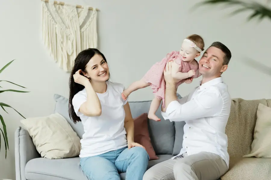 A happy married couple playing with their baby, showcasing a successful work-life balance